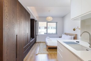 Une chambre à coucher avec un lit, une table de chevet et une fenêtre.