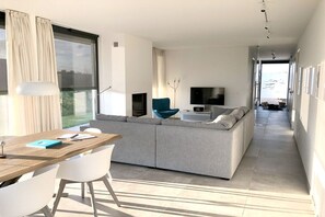 Ein modernes Wohnzimmer mit einer Couch, einem Esstisch und Stühlen.