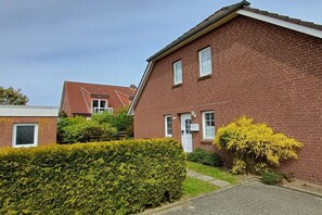 A residential building with a brick facade, a visible door, and a small window. - Holiday apartment with 2 bedrooms (Cuxhaven)