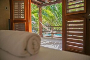 A room with a hammock, wooden slats, and a view of palm trees. - Hotel Buenavista Bacalar by NAH Hotels (Bacalar)
