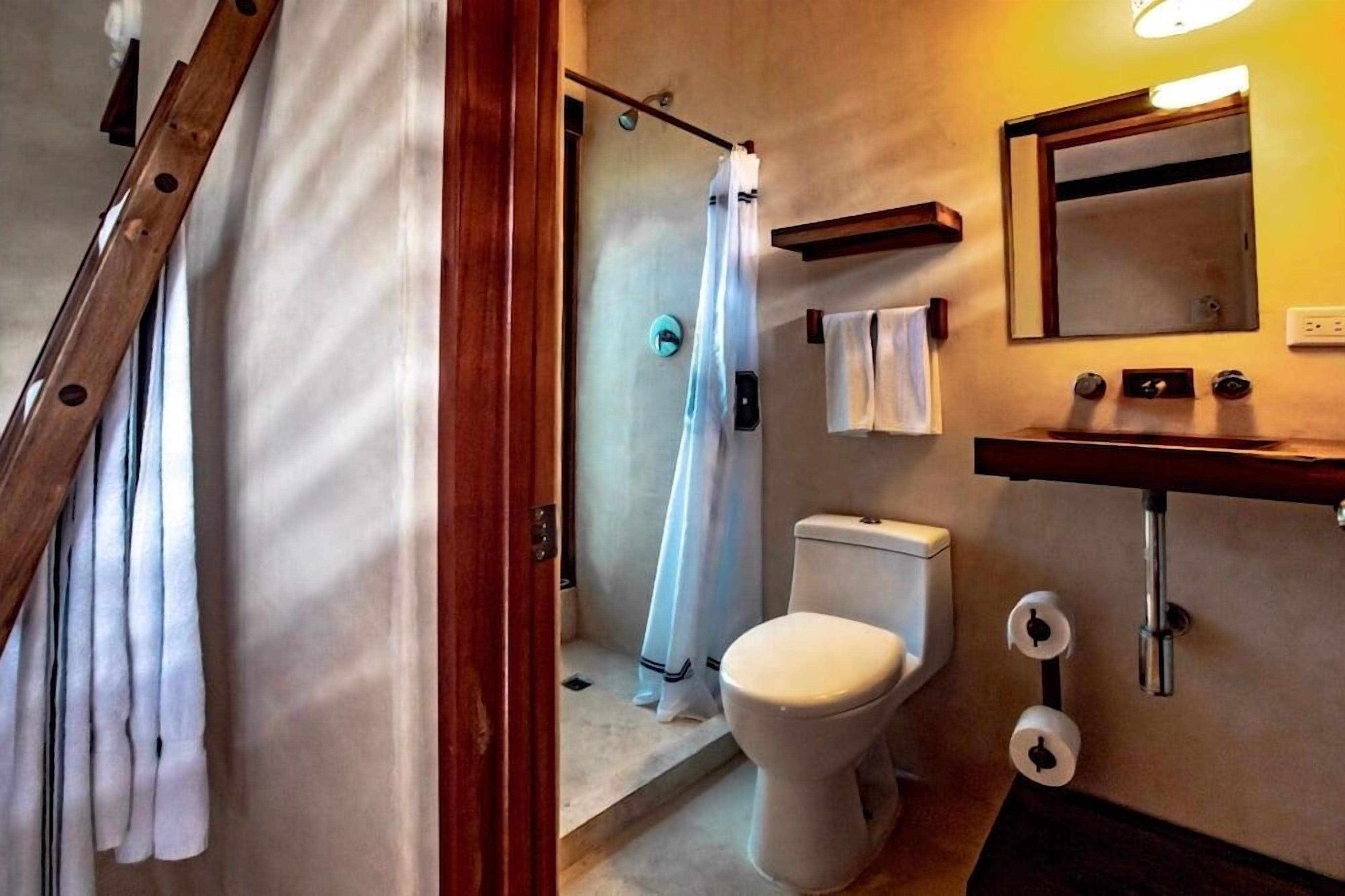 A bathroom with a shower, toilet, and sink.