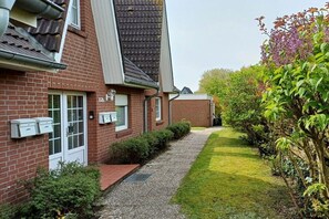 Ein Wohnhaus mit Backsteinfassade, einem Kiesweg und einem gepflegten Rasen.