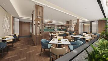 A modern restaurant interior with wooden flooring, multiple dining tables, and chairs.