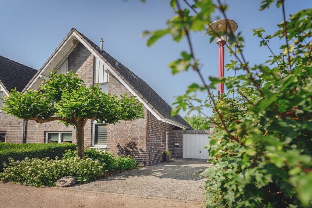 A residential building with a brick facade, a sloped roof, and a garage.