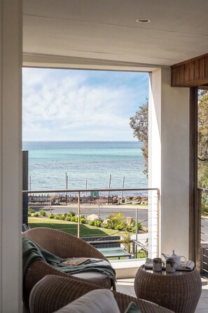 A balcony with a view of the ocean, wicker furniture, and a table with a teapot and cups. - Stillwater House - Poolside Serenity by the Bay (Dunsborough)