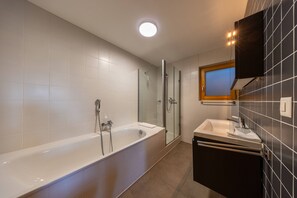 Ein modernes Badezimmer mit Badewanne, Dusche und Waschbecken.