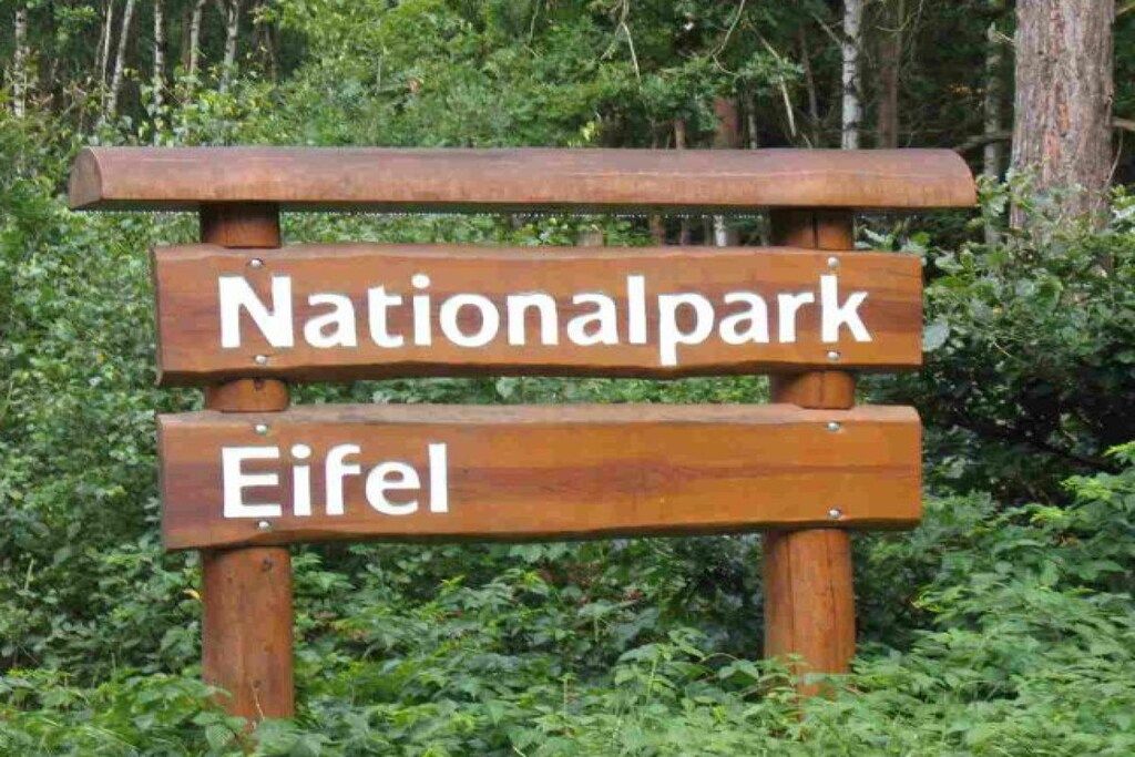 A wooden sign with the words 'Nationalpark' and 'Eifel' indicating a national park location.