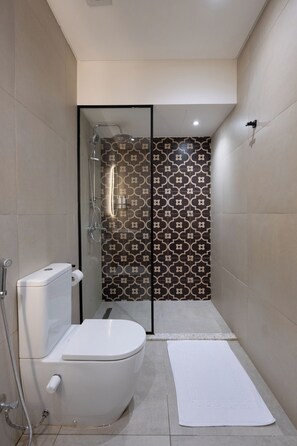 A modern bathroom with a toilet, shower, and a patterned wall. - Exclusuive offer for you at 88 by spacey (Cairo Governorate)