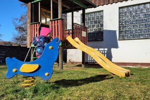 A playground with a slide and a swing set. - Holiday home in Rhön with 3 bedrooms (Hofbieber)