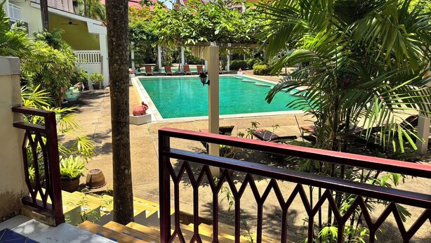 Un área de piscina con vistas a un edificio de techo rojo.