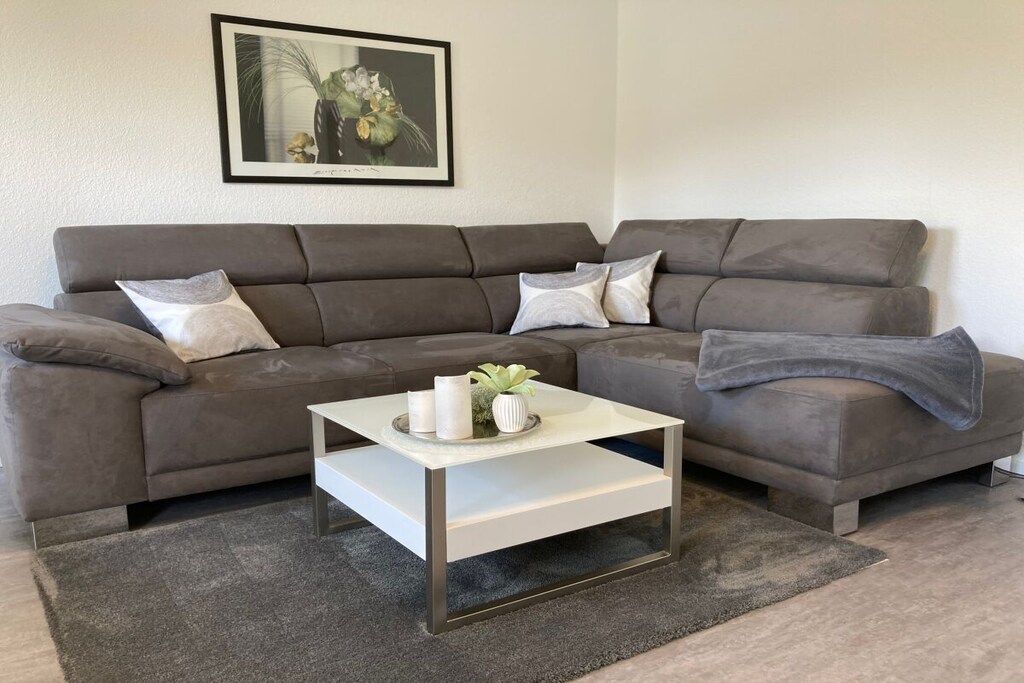 A living room with a sectional sofa, a coffee table, and a framed picture on the wall.