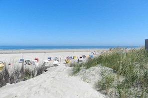 A beach with sand dunes and beach chairs. - Friesennest Langeoog (Langeoog)