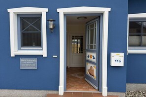 A blue building with a white-framed door, a window with a cross pattern, and a mailbox with the number 11a. - Holiday home in Zingst with swimming pool (Zingst)