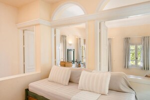 Un dormitorio con cama, ventana y espejo que refleja la habitación.