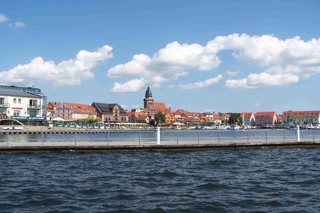 Une vue urbaine sur le front de mer, avec des bâtiments, un pont et une étendue d’eau.