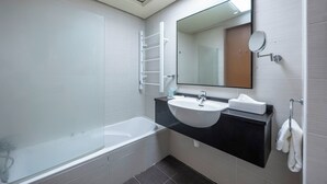 Ein modernes Badezimmer mit einer Badewanne, einem Waschbecken und einem Spiegel.
