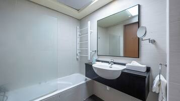 A modern bathroom with a bathtub, a sink, and a mirror.