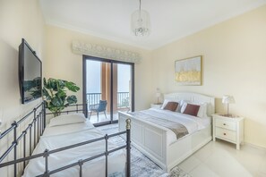 A bedroom with a bed, a nightstand, a chair, a plant, and a view of the outside. - Bloomfields 2BR plus Maid  Mina Al Fajer (Dibba)