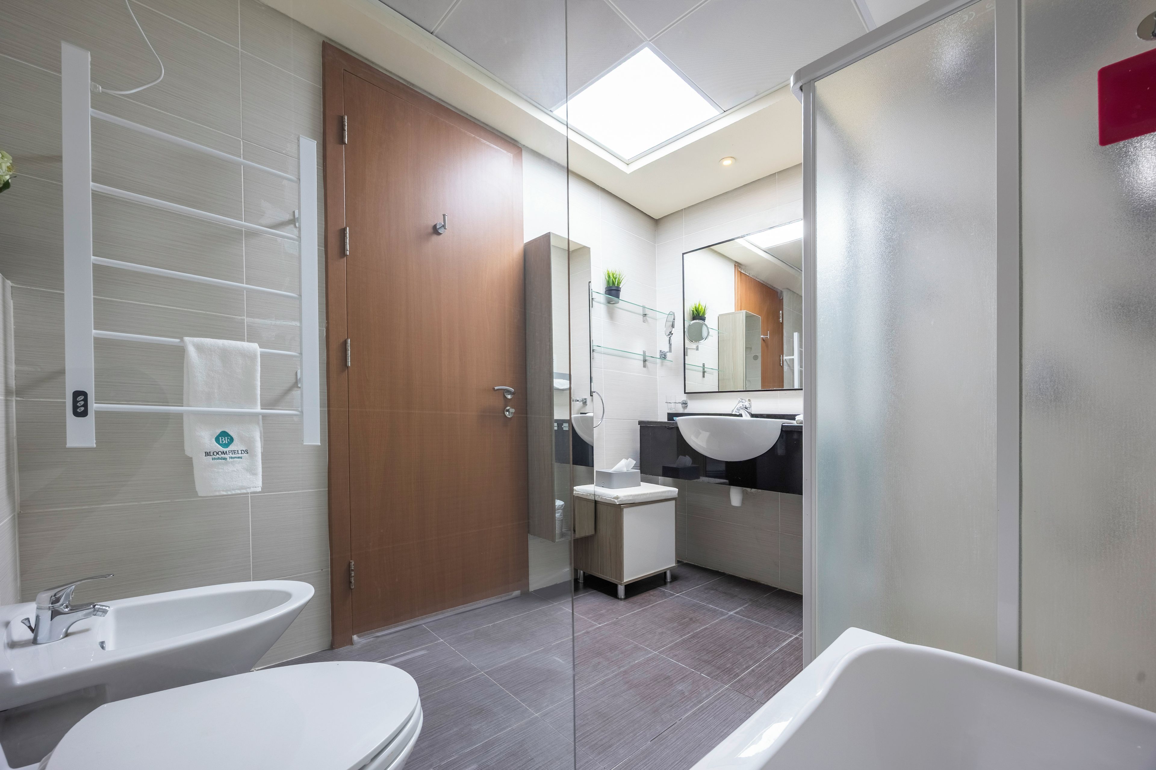 Een moderne badkamer met twee wasbakken, een grote spiegel en een douche.