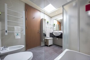 Une salle de bain moderne avec deux lavabos, un grand miroir et un espace douche.