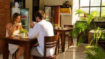 A dining area with wooden furniture and potted plants.