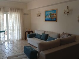 A living room with a sofa, a coffee table, and a painting on the wall.