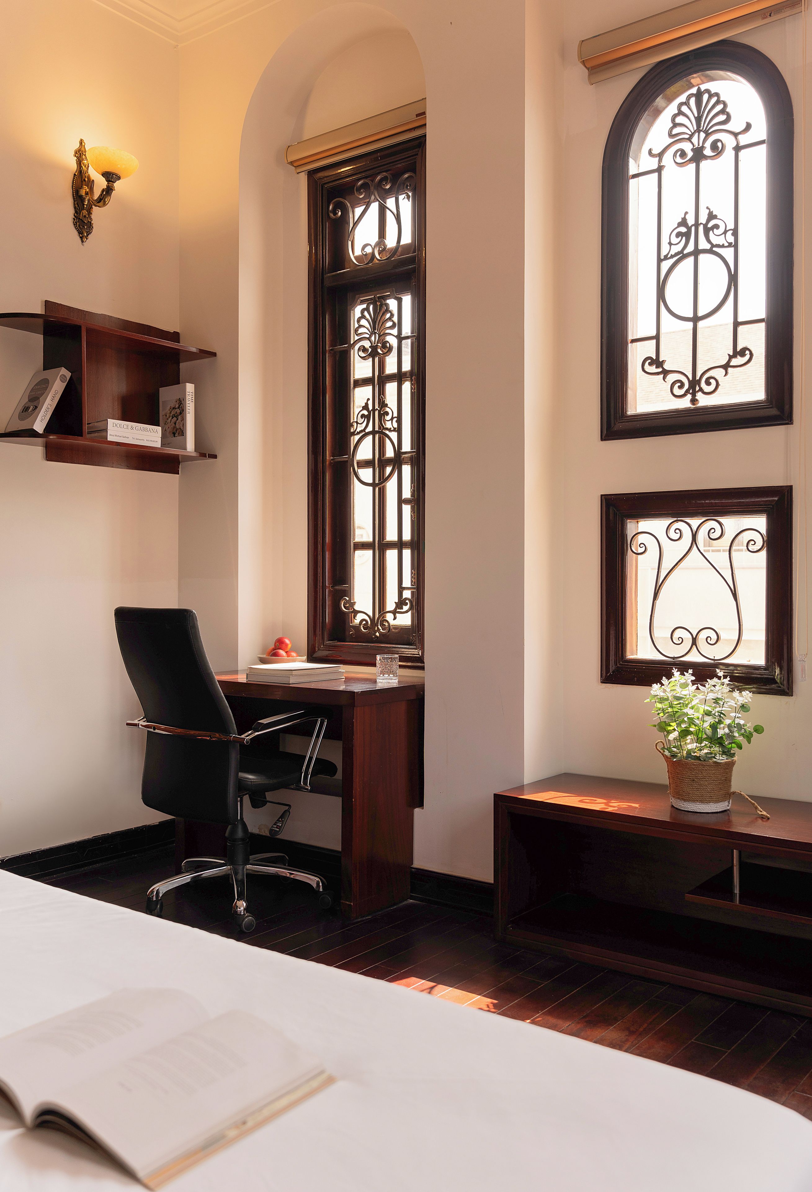 Una habitación con escritorio, silla y una planta en maceta.