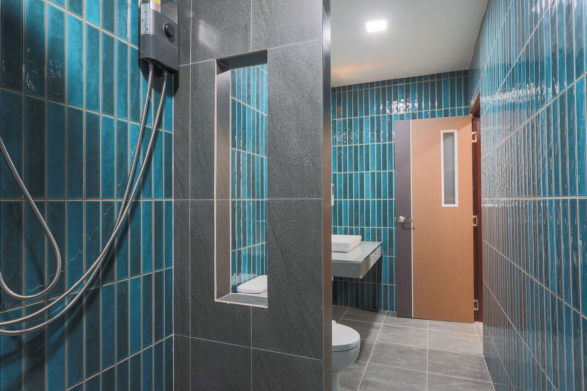 Een badkamer met een douche, toilet en wastafel.