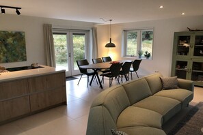 Eine moderne Küche mit Essbereich, einer Couch und einem Schrank.
