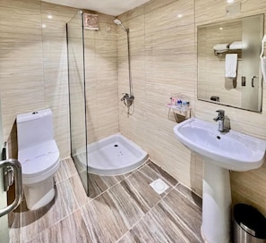 Ein modernes Badezimmer mit einer Duschkabine, einem Standwaschbecken und einer Toilette.