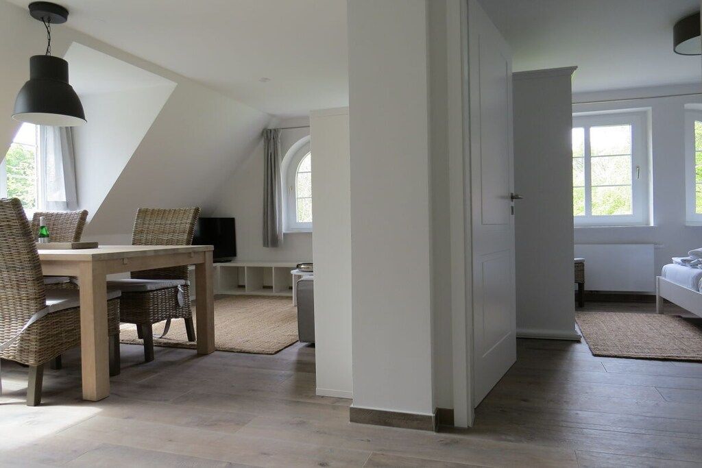 Une pièce comprenant une table et des chaises, un lit, une fenêtre et une porte.