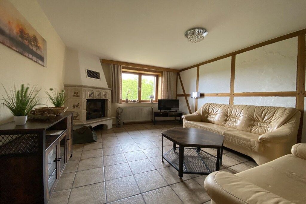 Una sala de estar con chimenea, televisor, sofá y mesa de centro.