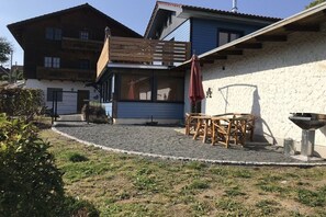 A two-story building with a wooden deck and a barbecue grill. - Holiday home in Stiege with barbecue (Stiege)