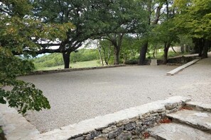 A gravel area with stone steps and trees, likely a park or outdoor seating area.