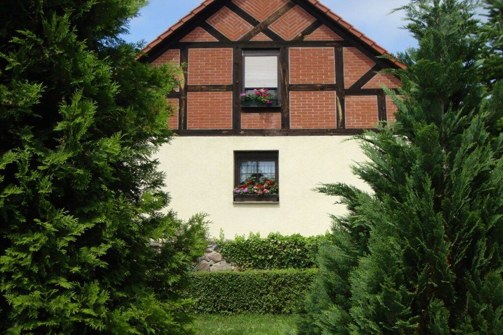 A traditional half-timbered house with a white facade and a pitched roof.