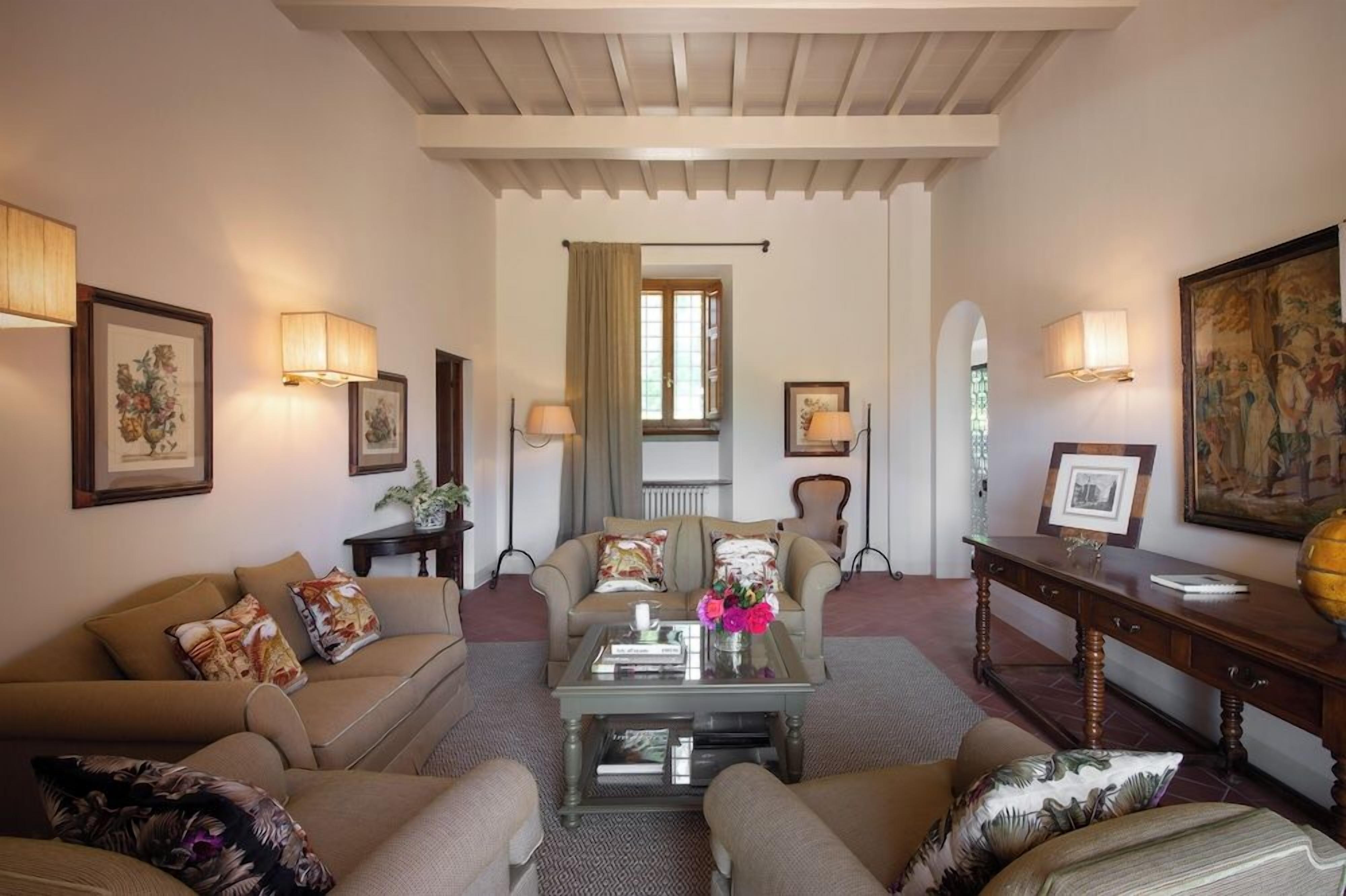 Una sala de estar acogedora con un conjunto de sofás, una mesa de centro y una mesita auxiliar de madera.