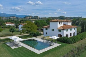 A villa with a swimming pool, outdoor seating, and a view of the surrounding landscape. - Viesca Suites & Villas Il Borro Toscana (Reggello)