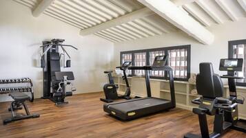 A gym with treadmills, weight machines, and dumbbells.