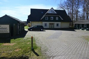 Een gebouw met een verharde oprit en een auto ervoor geparkeerd.