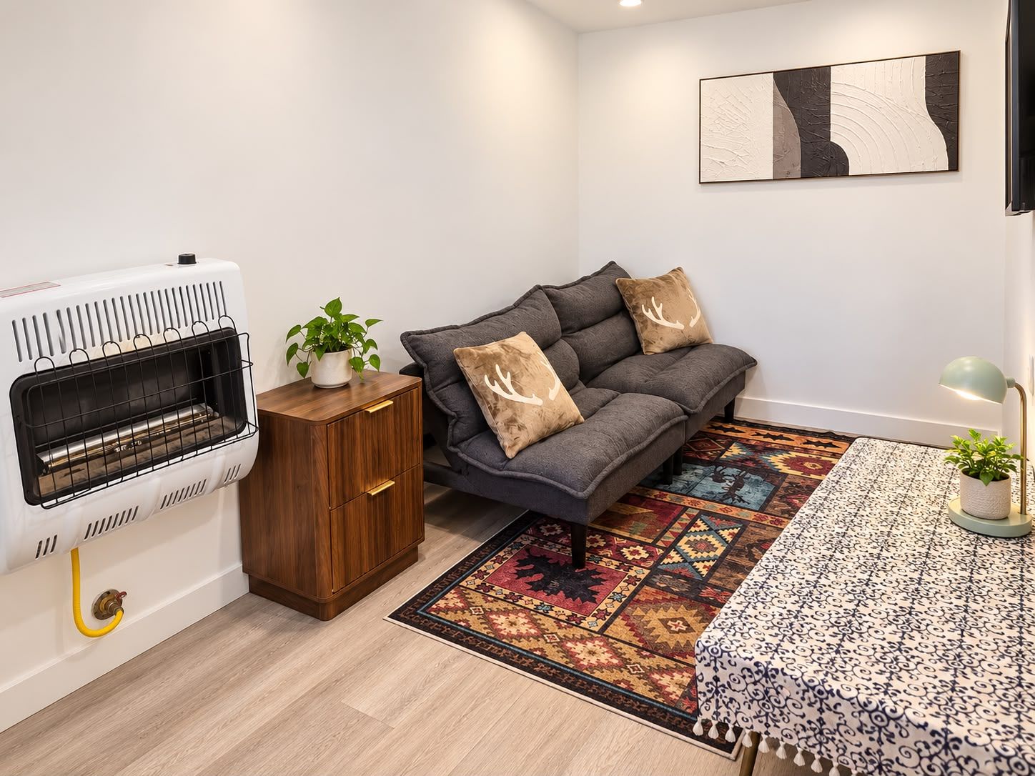 A modern living room with a fireplace, sofa, and patterned rug.