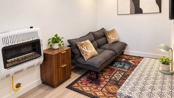 A modern living room with a fireplace, sofa, and patterned rug.