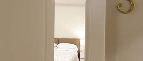 A hotel room with a bed, a nightstand, a lamp, and a door with the number 3.