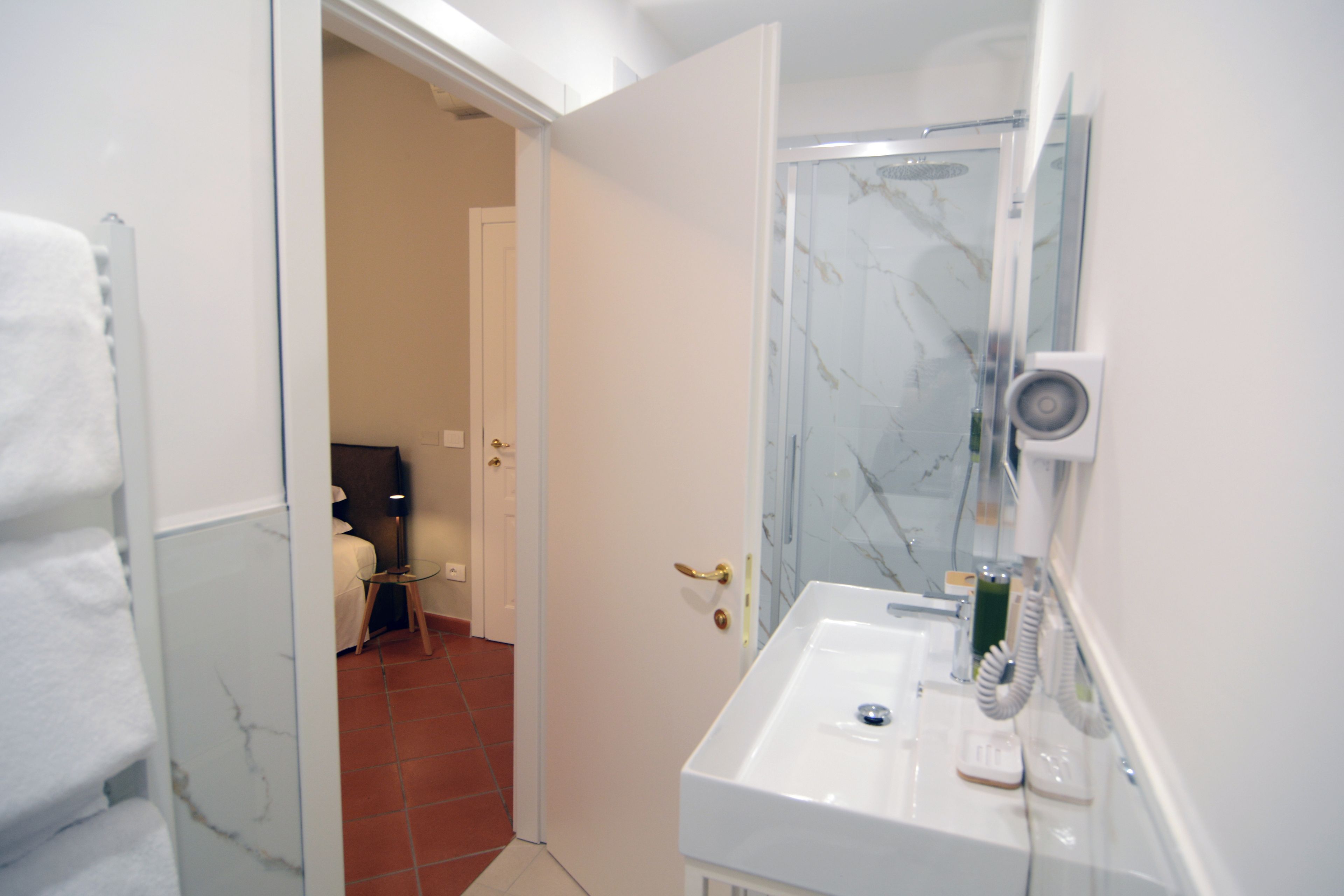 A bathroom with a white sink, a mirror, and a shower area.