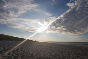 A beach with a clear sky, a sunbeam, and a distant horizon. - Holiday apartment with 1 bedroom (Prerow)