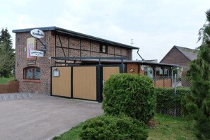 Un bâtiment en briques sur lequel on peut lire les inscriptions « Krombacher » et « Schwalbe-Bernhardt ».