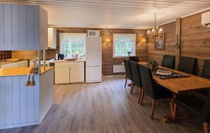 A compact kitchen with a dining area, wooden walls, and a window providing natural light. - 4 bedroom nice home in Bykle (Bykle)