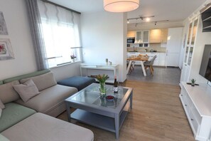 A modern living room with a glass coffee table, a sofa, and a dining area in the background. - Bad Kösen Wine Quarter (Naumburg)