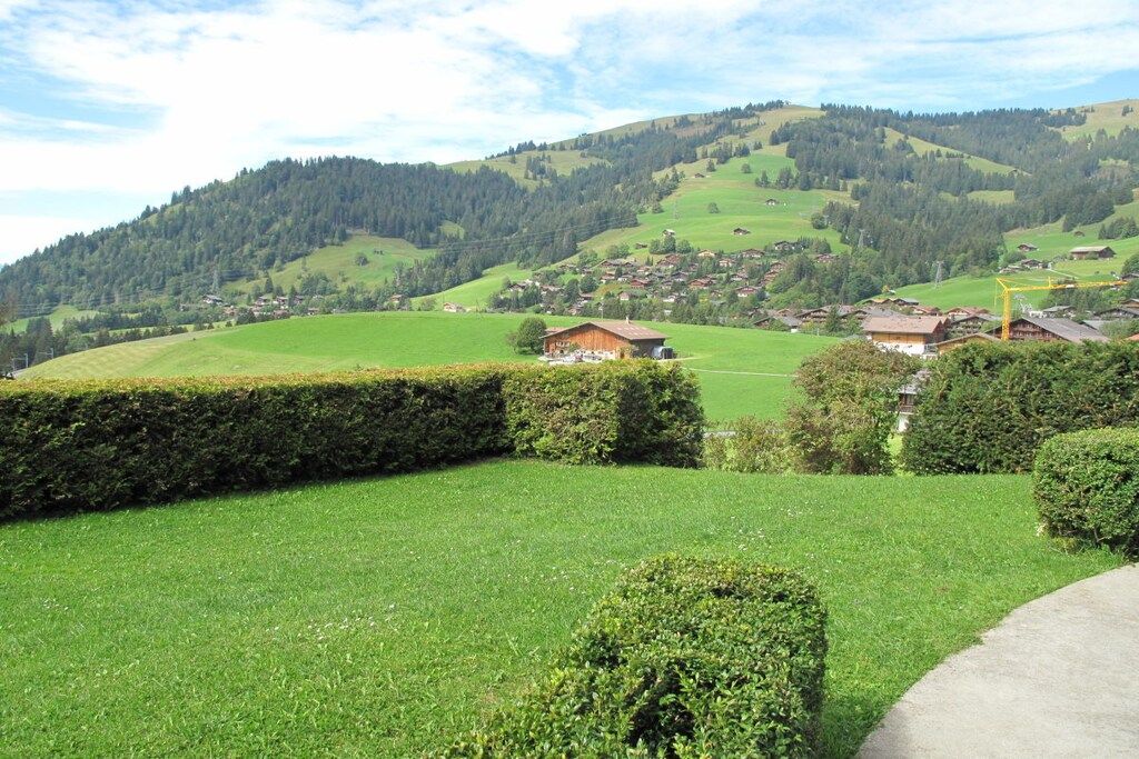 Un paisaje rural con colinas onduladas, un pequeño pueblo y cielo despejado.