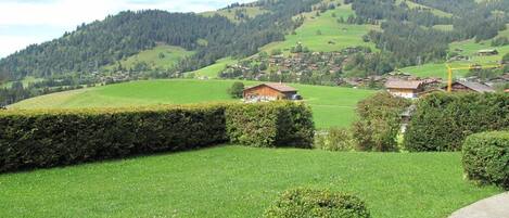 Un paisaje rural con colinas onduladas, un pequeño pueblo y cielo despejado.