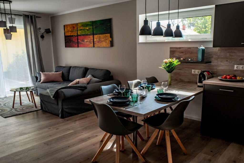 Un espace de vie moderne comprenant un coin repas, un canapé et une cuisine.